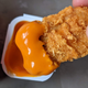 spicy mcnugget dipped into buffalo sauce